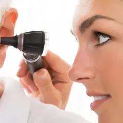 Lekarz bada ucho pacjenta otoskopem, szukając objawów choroby Meniere'a.