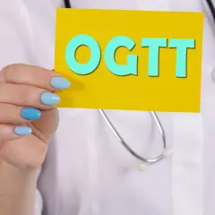 Lekarz trzyma kartkę z napisem OGTT, badanie kluczowe dla wykrycia cukrzycy ciążowej.