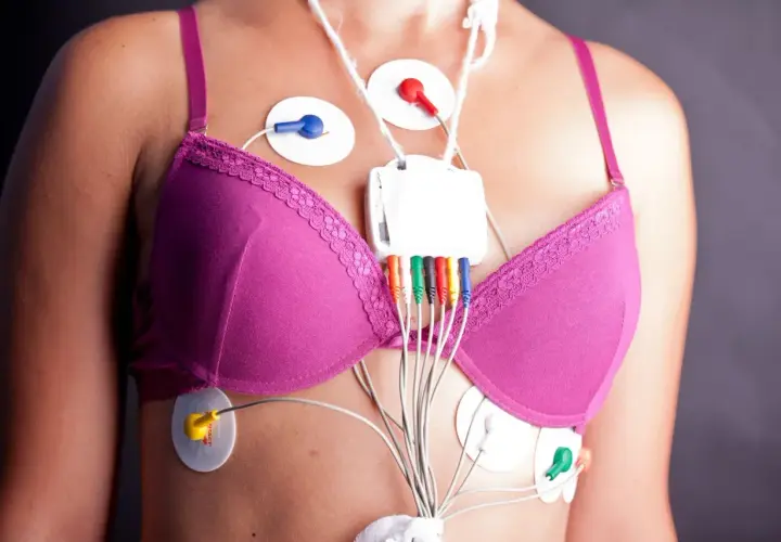 Kobieta z przyklejonymi elektrodami i urządzeniem do monitorowania holter ekg.