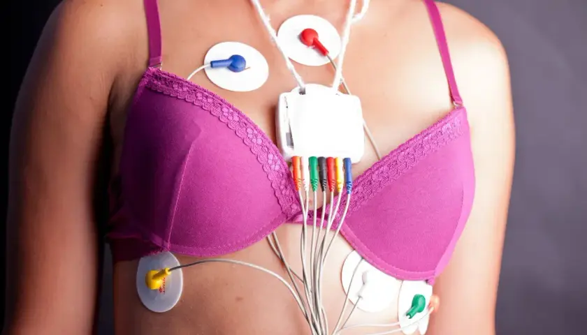 Kobieta z przyklejonymi elektrodami i urządzeniem do monitorowania holter ekg.